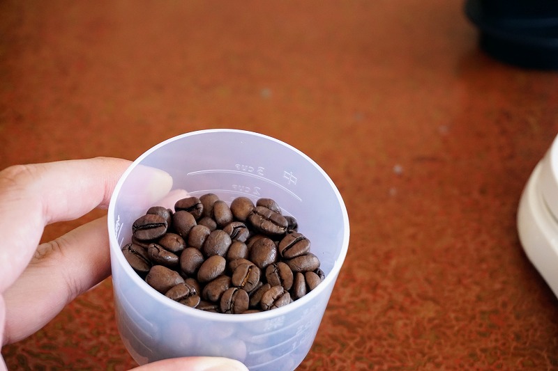 計量カップでコーヒー豆を計量